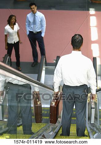 Stock Photo - Rear view of a businessman on an escalator. Fotosearch