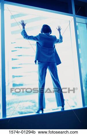 Rear view of a businesswoman leaning against a window View Large Photo Image Stock Image - Rear view of a businesswoman leaning against a window. Fotosearch
