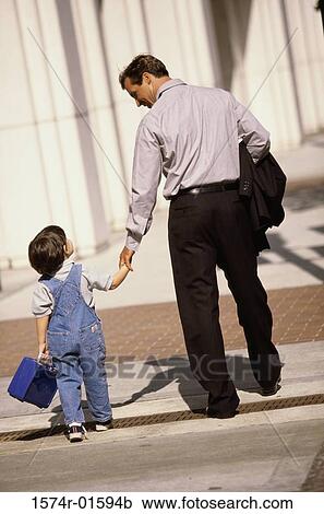Rear view of a father walking with his son View Large Photo Image Stock Image - Rear view of a father walking with his son. Fotosearch