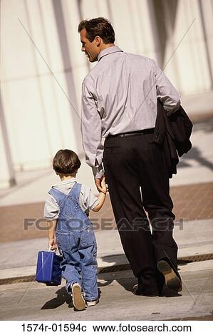 Rear view of a father walking with his son View Large Photo Image Stock Image - Rear view of a father walking with his son. Fotosearch
