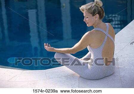 Rear view of a mid adult woman sitting on the floor meditating View Large Photo Image Stock Image - Rear view of a mid adult woman sitting on the floor meditating. Fotosearch