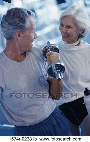 Senior couple exercising in a health club View Large Photo Image Stock Image - Senior couple exercising in a health club. Fotosearch