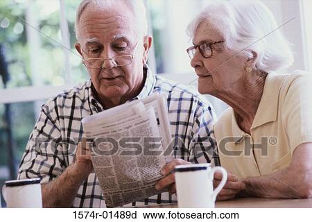 Stock Image - Senior couple reading a newspaper. Fotosearch