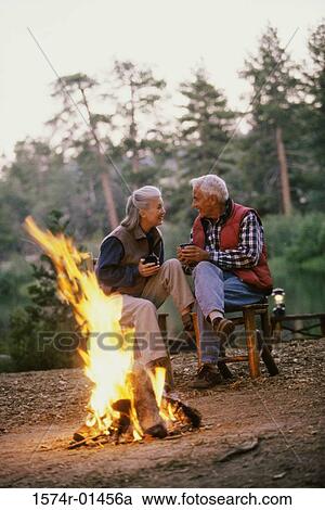 Senior couple sitting in front of a camp fire talking View Large Photo Image Stock Image - Senior couple sitting in front of a camp fire talking. Fotosearch