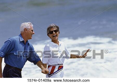 Senior couple walking at the beach View Large Photo Image Stock Image - Senior couple walking at the beach. Fotosearch