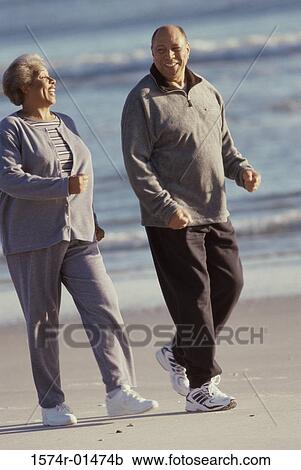 Senior couple walking at the beach View Large Photo Image Stock Image - Senior couple walking at the beach. Fotosearch