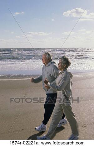 Senior couple walking on the beach View Large Photo Image Stock Image - Senior couple walking on the beach. Fotosearch