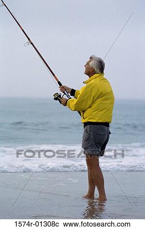Stock Image - Senior man fishing at the beach. Fotosearch
