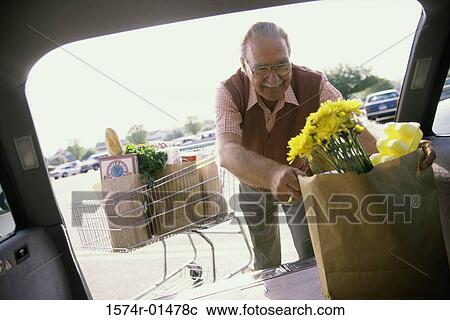 Senior man putting shopping bags into his car View Large Photo Image Stock Image - Senior man putting shopping bags into his car. Fotosearch