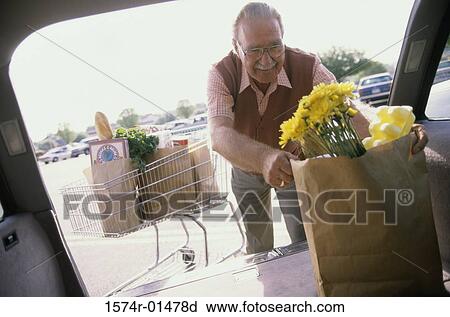 Senior man putting shopping bags into his car View Large Photo Image Stock Image - Senior man putting shopping bags into his car. Fotosearch