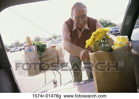 Senior man putting shopping bags into his car View Large Photo Image Stock Image - Senior man putting shopping bags into his car. Fotosearch