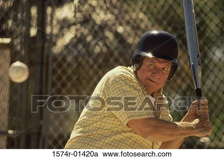 Senior man swinging a baseball bat View Large Photo Image Stock Image - Senior man swinging a baseball bat. Fotosearch