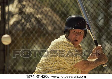 Stock Image - Senior man swinging a baseball bat. Fotosearch