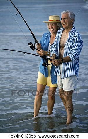 Senior man teaching a senior woman fishing at the beach View Large Photo Image Stock Image - Senior man teaching a senior woman fishing at the beach. Fotosearch