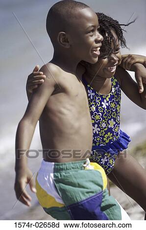 Side profile of a girl and a boy holding each other on the beach View Large Photo Image Stock Image - Side profile of a girl and a boy holding each other on the beach. Fotosearch