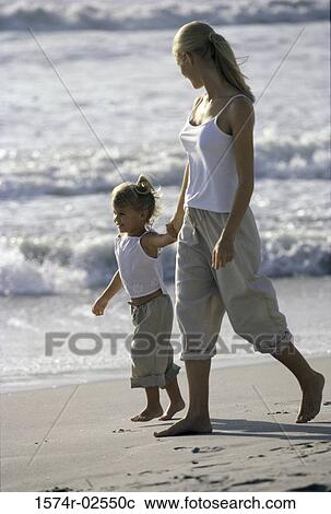 Side profile of a mother and her daughter walking on the beach View Large Photo Image Stock Image - Side profile of a mother and her daughter walking on the beach. Fotosearch