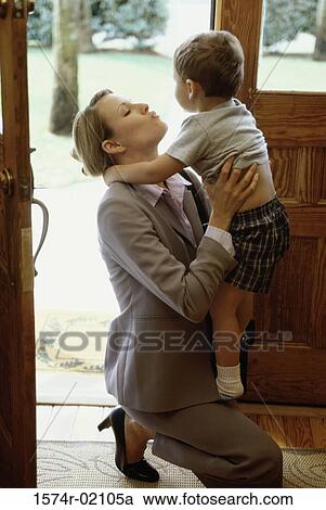 Stock Image - Side profile of a mother kissing her son. Fotosearch