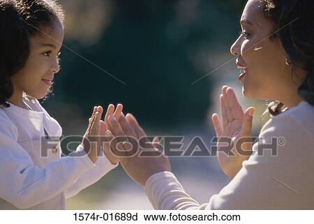 Side profile of a mother playing pattycake with her daughter View Large Photo Image Stock Image - Side profile of a mother playing pattycake with her daughter. Fotosearch