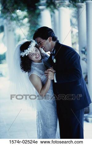 Stock Image - Side profile of a newlywed couple dancing together. Fotosearch
