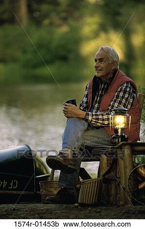 Side profile of a senior man sitting on a chair beside a lamp View Large Photo Image Stock Image - Side profile of a senior man sitting on a chair beside a lamp. Fotosearch