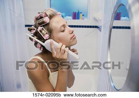 Stock Image - Side profile of a teenage girl looking into a mirror. Fotosearch