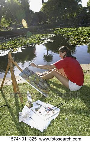 Side profile of a young woman painting by a lake View Large Photo Image Stock Photography - Side profile of a young woman painting by a lake. Fotosearch