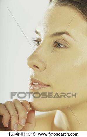Side profile of a young woman with her hand on her chin View Large Photo Image Stock Image - Side profile of a young woman with her hand on her chin. Fotosearch