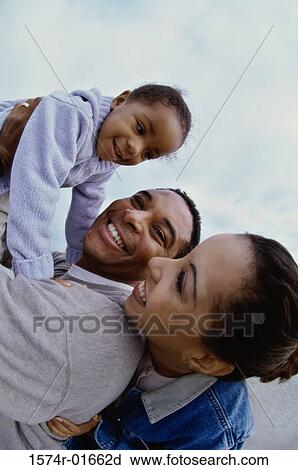 Stock Image - Side profile of parents with their daughter. Fotosearch