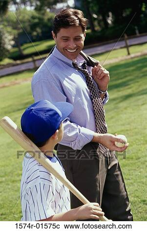 Stock Image - Side view of a father walking with his son. Fotosearch