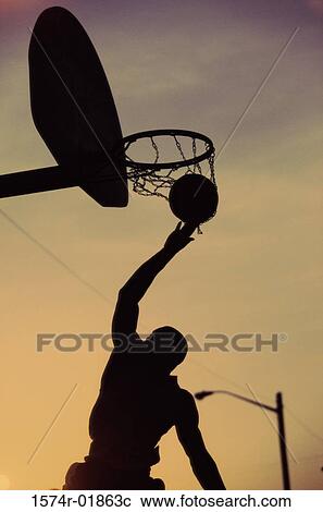 Silhouette of a young man playing basketball View Large Photo Image Stock Image - Silhouette of a young man playing basketball. Fotosearch
