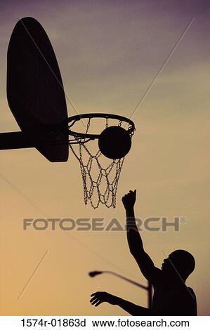 Stock Image - Silhouette of a young man playing basketball. Fotosearch