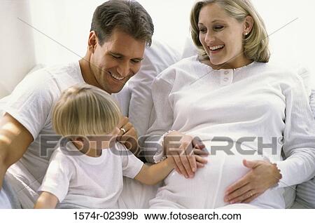 Son touching his pregnant mother's abdomen View Large Photo Image Stock Image - Son touching his pregnant mother's abdomen. Fotosearch