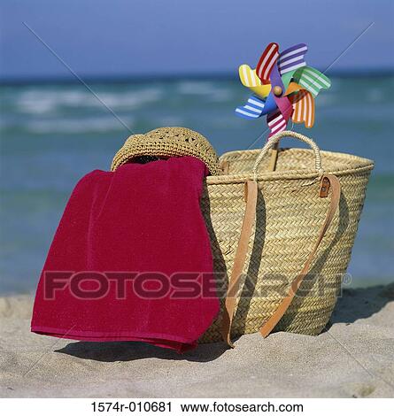Straw bag with a towel a hat and a pinwheel on the beach View Large Photo Image Stock Image - Straw bag with a towel a hat and a pinwheel on the beach. Fotosearch