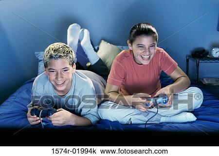 Teenage boy and a teenage girl playing video games View Large Photo Image Stock Image - Teenage boy and a teenage girl playing video games. Fotosearch
