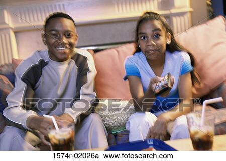 Stock Image - Teenage boy and a teenage girl watching television. Fotosearch