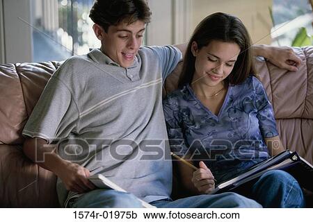 Teenage couple sitting together on a couch View Large Photo Image Stock Image - Teenage couple sitting together on a couch. Fotosearch