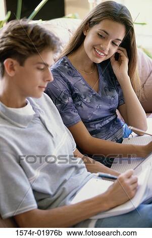 Teenage couple sitting together on a couch View Large Photo Image Stock Image - Teenage couple sitting together on a couch. Fotosearch
