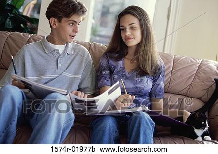 Teenage couple sitting together on a couch View Large Photo Image Stock Image - Teenage couple sitting together on a couch. Fotosearch