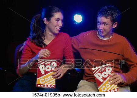 Teenage girl and a young man looking at each other at a movie theater View Large Photo Image Stock Image - Teenage girl and a young man looking at each other at a movie theater. Fotosearch