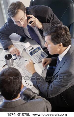Stock Image - Three businessmen having a discussion. Fotosearch