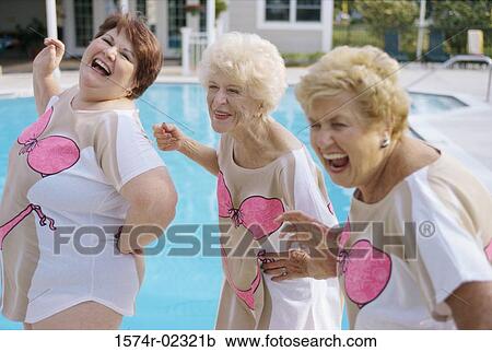 Stock Image - Three senior women standing near a swimming pool. Fotosearch