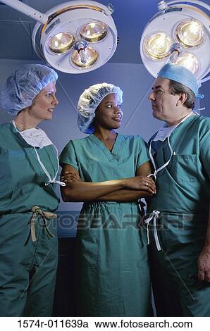 Three surgeons standing in an operating room View Large Photo Image Stock Image - Three surgeons standing in an operating room. Fotosearch
