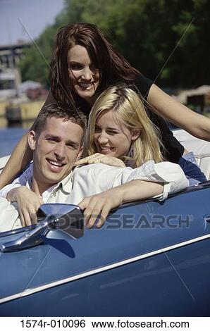 Stock Photograph - Three young people in a convertible car. Fotosearch
