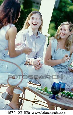 Three young women sitting together View Large Photo Image Stock Image - Three young women sitting together. Fotosearch