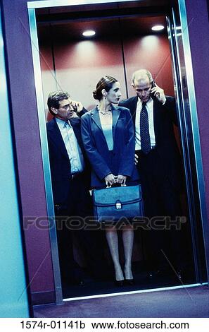 Stock Image - Two businessmen and a businesswoman in an elevator. Fotosearch