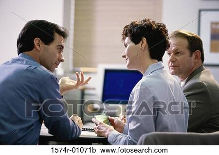 Two businessmen and a businesswoman having a discussion View Large Photo Image Stock Image - Two businessmen and a businesswoman having a discussion. Fotosearch