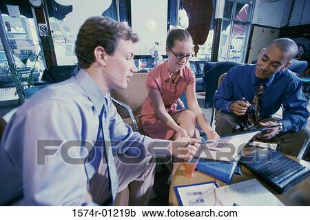 Stock Image - Two businessmen and a businesswoman talking. Fotosearch