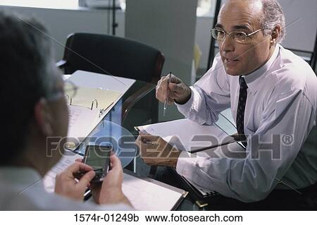 Two businessmen having a discussion in an office View Large Photo Image Stock Image - Two businessmen having a discussion in an office. Fotosearch