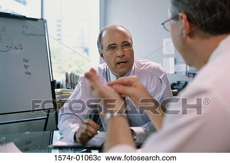 Two businessmen having a discussion View Large Photo Image Stock Image - Two businessmen having a discussion. Fotosearch