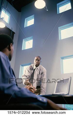 Two businessmen talking in an office View Large Photo Image Stock Image - Two businessmen talking in an office. Fotosearch